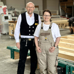 Eine Frau und ein Mann stehen in einem Zimmermeisterbetrieb in der Fertigungshalle