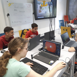 Schülerinnen und Schüler sitzen an Laptops und arbeiten mit dem Programm Blender