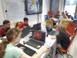 Schülerinnen und Schüler sitzen an Laptops und arbeiten mit dem Programm Blender